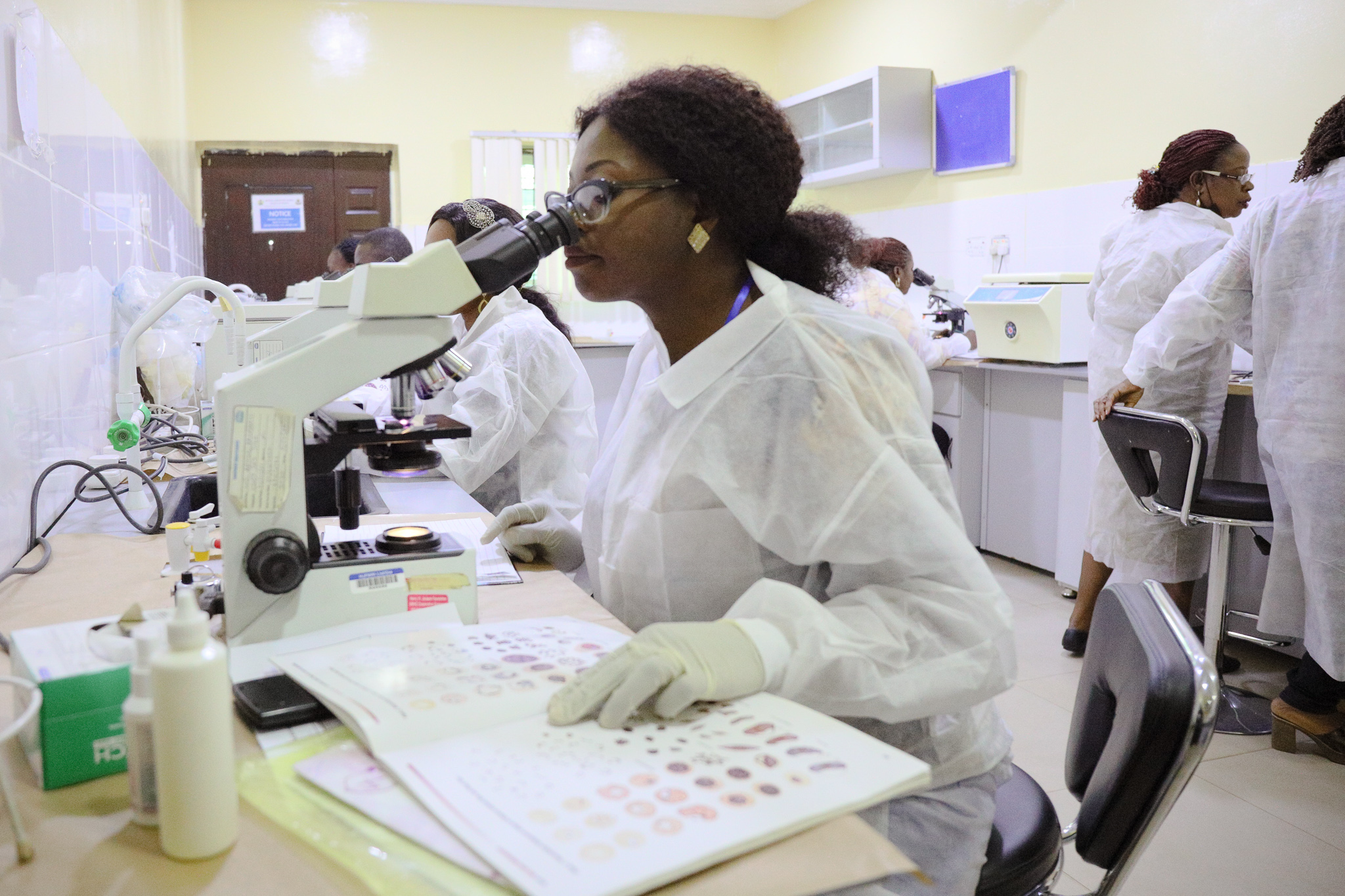 Photo of scientist looking in microscope. 