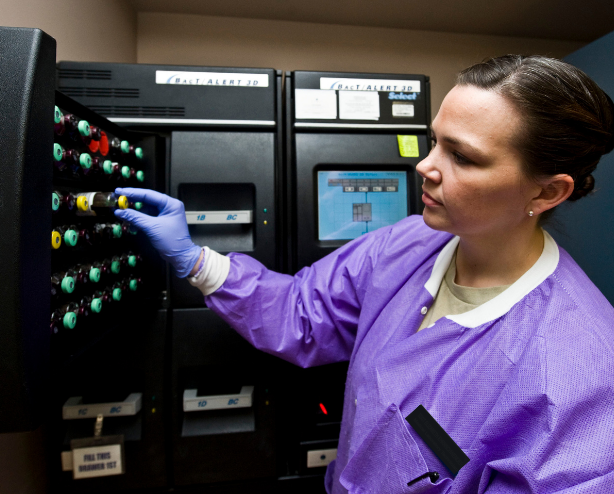 Woman unloads blood cultures from a machine that detects sepsis