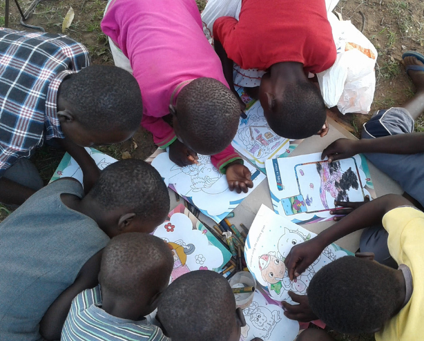 Children in Kenya draw on coloring pages
