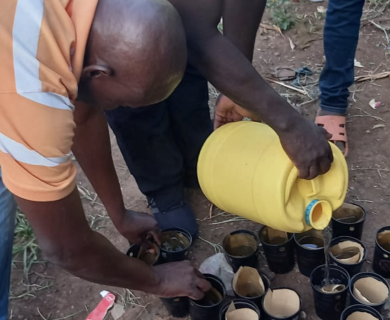 Two men fill cups with water