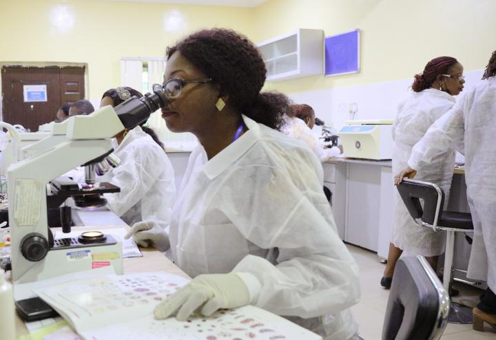Photo of scientist looking in microscope.