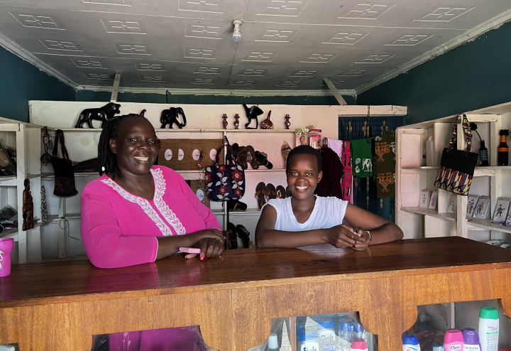 Two women smile behind a shop counter