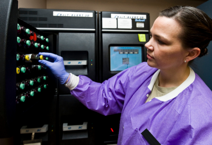 Woman unloads blood cultures from a machine that detects sepsis