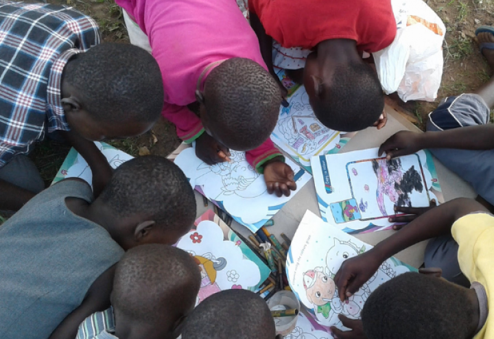 Children in Kenya draw on coloring pages
