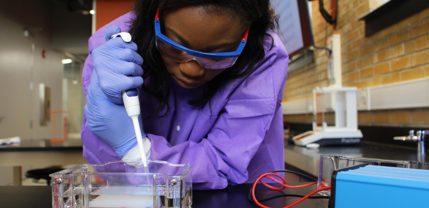 Scientist using a pipette at a lab bench