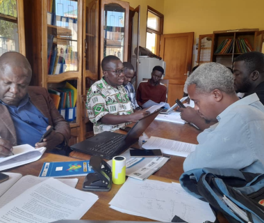 Men sitting around a table with training documents