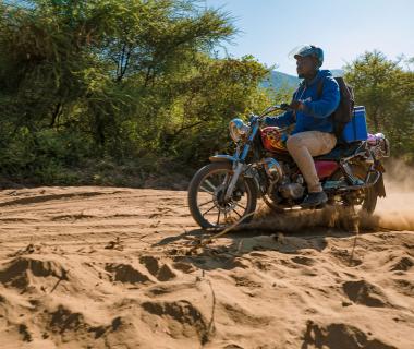 A motorcycle drives on sand